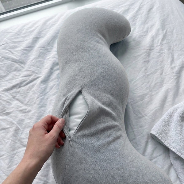 Hand unzipping the grey Cuddle Curve cover to show the inner pillow